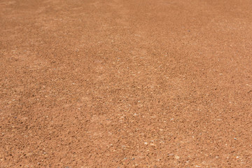 Flat orange dirt and gravel pavement space close-up