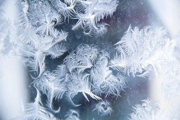 Frosty patterns on a winter window in cold colors.