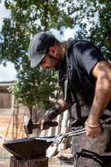 blacksmith working on an anvil. Blacksmith forging red-hot metal with hammer. Blacksmith concept