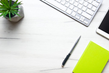 White desk office with laptop, smartphone and other work supplies with cup of coffee. Top view with copy space for input the text. Designer workspace on desk table essential elements on flat lay