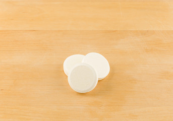 large round pills on wooden background