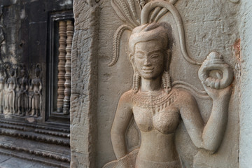Fototapeta na wymiar Bas-relief mural of the woman Apsara on wall Angkor Wat temple complex, close up