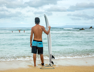 Surfer man holding surf board standing in the ocean