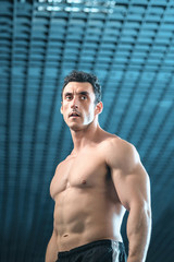Obraz premium Bodybuilder guy with naked torso stands in the gym