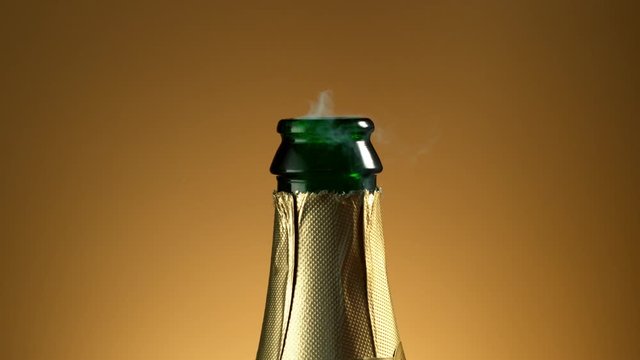 Super slow motion of Champagne explosion with flying cork closure, opening champagne bottle closeup.