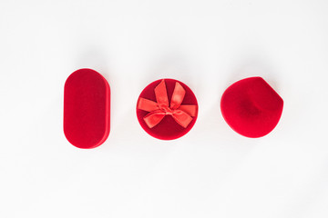 Three red closed jewelry boxes on a white background. Top view