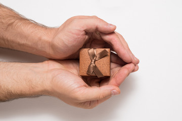 Brown jewelry box in man hands. Present. White background
