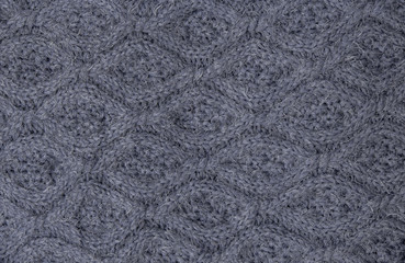 Beautiful gray knitted pattern, knitted scarf close up. Knitted background