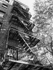 classic downtown Greenwich Village brick building facade with trees in black and white
