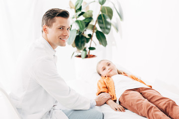 pediatrist in white coat examining child in clinic