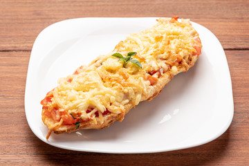 Bruschetta with tomatoes, mozzarella cheese and basil on a wooden background. Traditional italian appetizer or snack, antipasto. Isolated