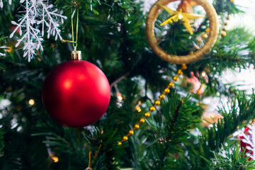 Christmas tree decorated with Red balls toys on a white wall, copy space.