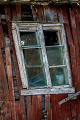 derelicted cottage with warped window on island Heroy, Nordland, Norway