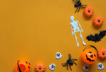 Halloween holiday concept, Pumpkin, bats, white skeleton and tiny ghost in orange background with copy space for text, Top flat view wallpaper