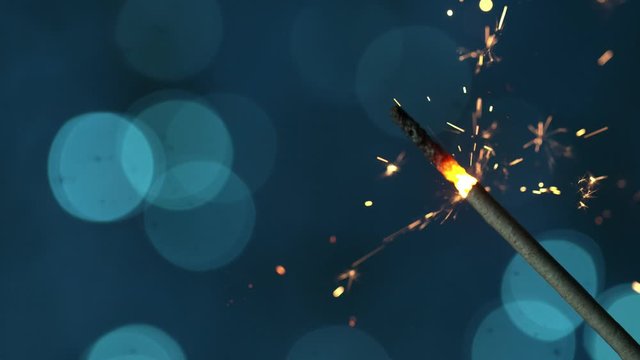 Super slow motion of burning sparkler on light blue background. Filmed on high speed cinema camera, 1000fps.