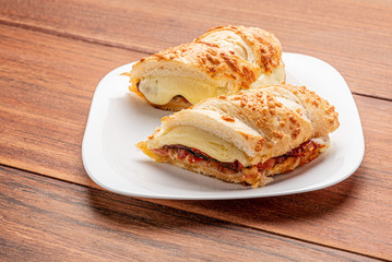 Beef steak sandwich with cheese and tomato, isolated on wooden background