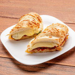 Beef steak sandwich with cheese and tomato, isolated on wooden background