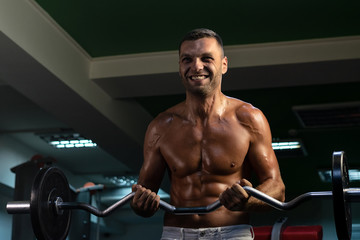 Fototapeta na wymiar muscular bodybuilder doing exercise on bars in the gym. a handsome, sporty, sexy guy with a abs training in the gym. fitness, bodybuilding, nutrition, healthy lifestyle