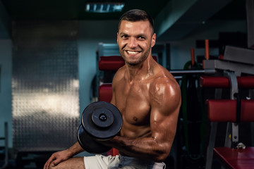 Fototapeta na wymiar smiling handsome man. muscular bodybuilder doing exercise on bars in the gym. a handsome, sporty, sexy guy with a abs training in the gym. fitness, bodybuilding, nutrition, healthy lifestyle