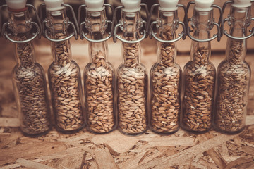 Glasses filled with different malts and hops over a wooden background. Variety of malt for brewery.