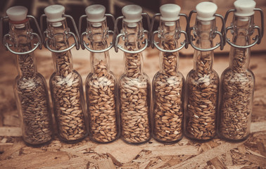 Glasses filled with different malts and hops over a wooden background. Variety of malt for brewery.