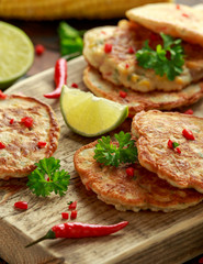 Corn fritters, pancake with dip white sauce, lime and chilli on wooden board