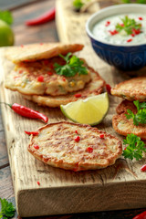 Corn fritters, pancake with dip white sauce, lime and chilli on wooden board