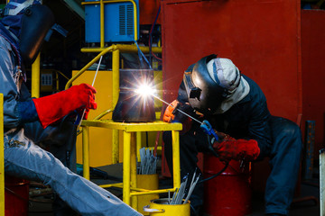 two welder man are welding joint reduce pipe