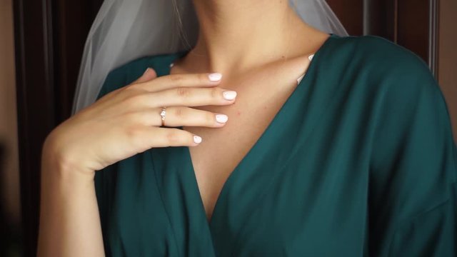 A woman in a beautiful green robe. A beautiful woman is stroking her collarbone. Woman in underwear stroking her legs. A woman with a beautiful figure in her underwear.