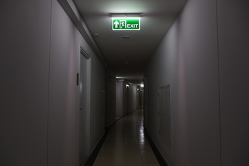 Emergency fire exit sign show the way to escape and low light in walk way