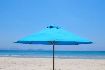 Beach umbrella on a beautiful sandy beach. panorama of a tropical beach with white sand and turquoise water. Travel and leisure concept. Tourist background. Screensaver on your computer.