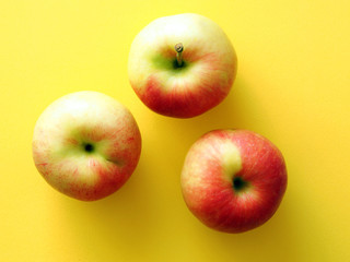Red-yellow apples on a yellow background. Vitamins and Health