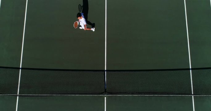 A tennis player volleys a great shot over the net and celebrates.