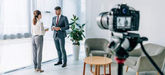 panoramic shot of journalist talking with businessman in formal wear