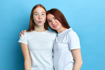 two awesome sisters wearing white T-shirts looking at the camera, close up portrait, family...