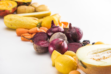 red onions, beetroots, carrots, lemons, zucchini and melon half on white background