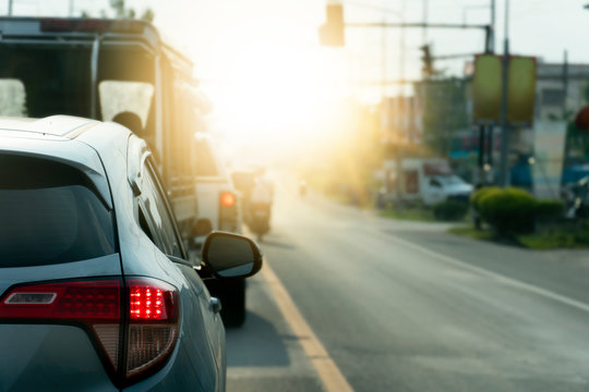 Brake cars on asphalt roads during rush hours for travel or business work. Open brake light and stop waiting for traffic lights at an intersection.