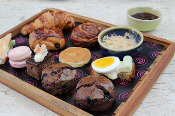 Luxury afternoon tea with dessert on wooden plate.