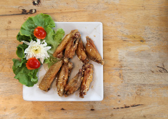 Fried chicken wings with sesame seeds on white plate.