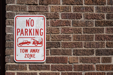 No Parking Sign on a Brick Wall. Tow away zone
