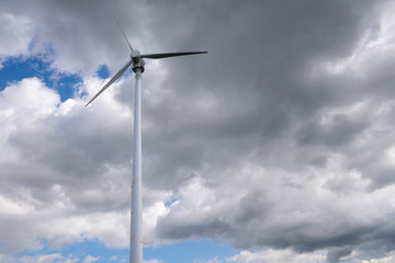 Fototapeta na wymiar Windkraftwerk mit wolkigem Hintergrund alleine
