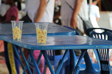 Pop corn in plastic clear glass on steel table.