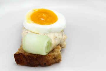 Sandwich with bread, salad dressing and boiled egg on white background.