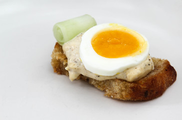 Sandwich with bread, salad dressing and boiled egg on white background.