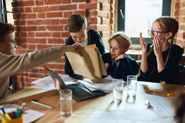 ginger clever boy in glasses showing the diagram to his colleagues, business kids analizing the spidegram