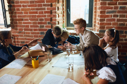 blonde boy in glasses and pretty girl with pigtails having an agument during the business meeting in the loft room. close up photo