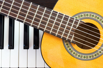 Closeup guitar on piano keyboard. Top view. Favorite music instrument.