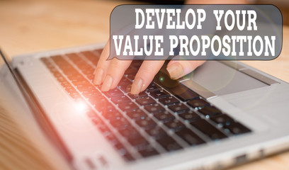 Writing note showing Develop Your Value Proposition. Business concept for Prepare marketing strategy sales pitch woman with laptop smartphone and office supplies technology