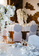 banquet round tables, decorated with a bouquet of white flowers