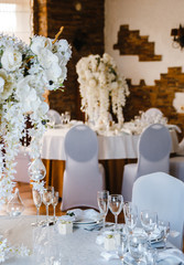 banquet round tables, decorated with a bouquet of white flowers
